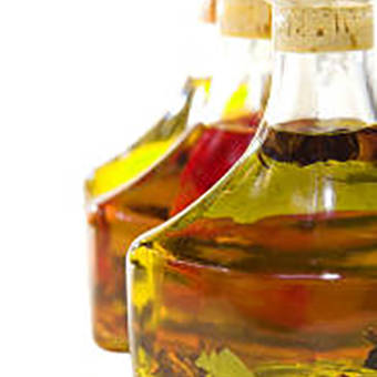 Three glass bottles filled with oils in different natural shades—golden yellow (Curcumin), vibrant orange (Annatto), and deep red (Paprika)—showcasing BioconColors oil-soluble natural colorants.